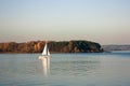 Beautiful lake landscape, yacht, and sunset. Blue waves, boat and horizon line on water. Beautiful background Royalty Free Stock Photo