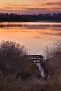 Beautiful lake near city with colorful sunset sky. Tranquil vibrant landscape