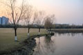 Beautiful lake scene with bare trees at sunset in Hangzhou city, China. Water reflection of trees and plants.