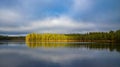 Beautiful lake scenery in Finland. Water mirroring the sky and the woods