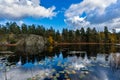 Beautiful lake or sea bay rocky shore on sunny autumn day. Water lily leaves cover the surface of water. Fall season landscape. Royalty Free Stock Photo