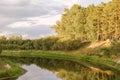 A beautiful lake surrounded by a lush green forest, reflecting the clear blue sky above.