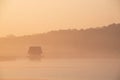 Beautiful landcape image of Spring sunrise over reservoir lake with dawn glow spreading aross the water with low mist adding