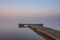 Beautiful landcape image of Spring sunrise over reservoir lake with dawn glow spreading aross the water with low mist adding