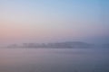 Beautiful landcape image of Spring sunrise over reservoir lake with dawn glow spreading aross the water with low mist adding