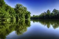 Beautiful landcsape, trees reflection in the lake water under blu Royalty Free Stock Photo