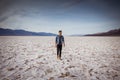 beautiful landscape of Bad Water course in death valley with young manr walking at sunset