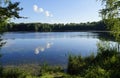 a beautiful landscape with the blue sky and white clouds reflecting in the calm water of a lake in Lauingen (Germany) Royalty Free Stock Photo