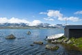 Boat on the shore of Lake Finsevatnet, snowy mountains and glacier Hardangerjokulen in Finse, Norway Royalty Free Stock Photo