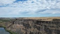 Beautiful landscape with a bridge over a river flowing along the cliffs under a cloudy sky Royalty Free Stock Photo