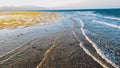 Beautiful landscape of calm ocean and the mountains on the coast. Sea waves rolling and braking over dead coral reef and Royalty Free Stock Photo