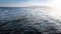 Beautiful landscape of calm ocean and the mountains on the coast. Sea waves rolling and braking over dead coral reef and Royalty Free Stock Photo