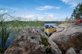 Beautiful landscape. Canoe parked on the sandy shore of the lake, with large stones, on a summer day. Lifestyle. Royalty Free Stock Photo
