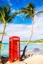 Beautiful landscape with a classic phone booth on the white sandy beach in Antigua Royalty Free Stock Photo