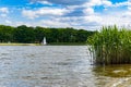 Beautiful landscape at cloudy day with boat swimming on river and green trees and bushes on both sides of river Royalty Free Stock Photo