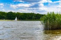 Beautiful landscape at cloudy day with boat swimming on river and green trees and bushes on both sides of river Royalty Free Stock Photo