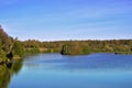 Beautiful landscape with colorful forest. Forest round the lake. Trees and sun reflected on the water