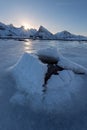 Beautiful landscape cracking ice, frozen sea coast with mountain ridge background at sunrise in winter season, Lofoten Islands, Royalty Free Stock Photo