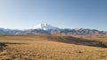 Beautiful landscape: desert highlands in autumn. View of mount Elbrus. Dry grass, rocks, mountains. Trip to the Caucasus in Russia Royalty Free Stock Photo