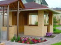 Beautiful landscape design in a private yard. Colorful flowers, green grass and trees. Cosy barbeque house / grill house.