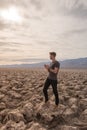 beautiful landscape of Devil's golf course in death valley with young manr walking at sunset