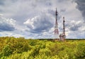 Landscape with dramatic sky and antenna towers in fresh green forest Royalty Free Stock Photo