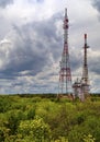 Landscape with dramatic sky and antenna towers in fresh green forest Royalty Free Stock Photo