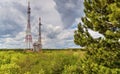 Landscape with dramatic sky and antenna towers in fresh green forest Royalty Free Stock Photo