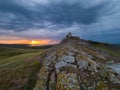 Beautiful landscape and a dramatic sunset sky with storm clouds over Enisala old stronghold citadel Royalty Free Stock Photo