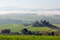 Beautiful landscape of farmhouses on the green grassy fields over rolling hills in idyllic Tuscan countryside Royalty Free Stock Photo