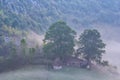 Beautiful landscape of a foggy morning with an old house and trees Royalty Free Stock Photo