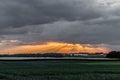 Beautiful landscape of a green field cultivated in a wonderful sunset with the rays of the sun rising through the clouds