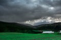 A beautiful landscape with a green fields of Norway, mountain and cloudy sky Royalty Free Stock Photo