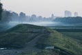 Beautiful landscape of green hills with silhouettes of three people in the mist