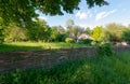 Beautiful landscape of green trees against a blue sky. Standing behind the fence and near the house with a thatched roof Royalty Free Stock Photo