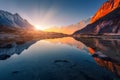 Mountains with illuminated peaks, stones in mountain lake at sunset Royalty Free Stock Photo