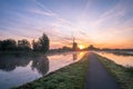 Beautiful landscape image with traditional dutch windmill and low fog at sunrise Royalty Free Stock Photo