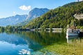Beautiful landscape with lake, boat, mountain, forest and reflection on the water in Austrian Alps. Wallpaper. Royalty Free Stock Photo