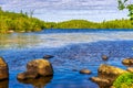 Beautiful landscape with lake and stone boulders in northern forest on summer sunny day. Amazing scenery with pond among woodland Royalty Free Stock Photo