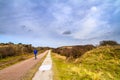 Beautiful landscape - lonely cyclist who rides the bike path among the dunes