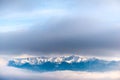 Beautiful landscape of a mountain crest covered in snow in the clouds