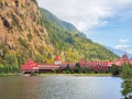 Beautiful landscape of a mountain and lake with red buildings on a shore. Three Valley Gap Lake Chateau Hotel BC, Canada