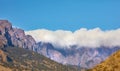 Beautiful landscape of a mountain top covered in clouds with clear blue sky copy space above and hills below. A peaceful Royalty Free Stock Photo