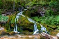 Beautiful landscape with mountain wild stream on green hills with moss