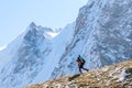 Beautiful landscape with mountains, blue huge glacier and silhouette of a man walking with a large backpack and guitar