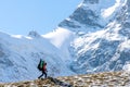 Beautiful landscape with mountains, blue huge glacier and silhouette of a man walking with a large backpack and guitar