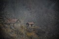 Beautiful landscape of mountains and forest with village building or old abandoned ruined brick house. Foggy forest and old buildi