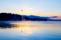 Beautiful landscape with mountains and lake at dawn in golden, blue and purple tones.