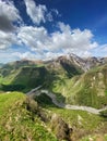 Beautiful landscape with mountains and peaks in the snow and a valley with roads and a lake on a summer sunny day with blue skies Royalty Free Stock Photo