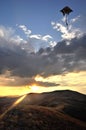 Beautiful landscape in the mountains at sunset. Rays of sun shining through the clouds Kite flying in the sky Royalty Free Stock Photo